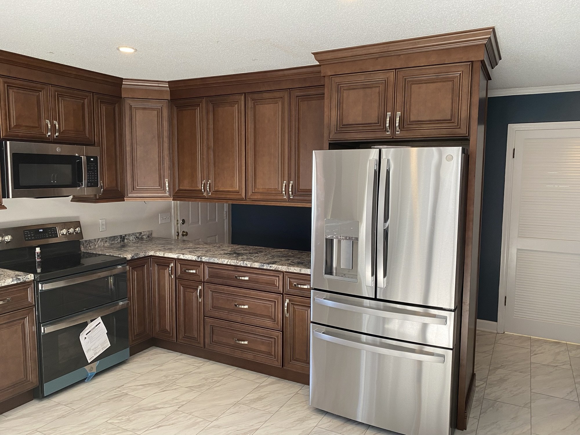 Glazed maple raised panel kitchen cabinets with crown molding and granite countertops
