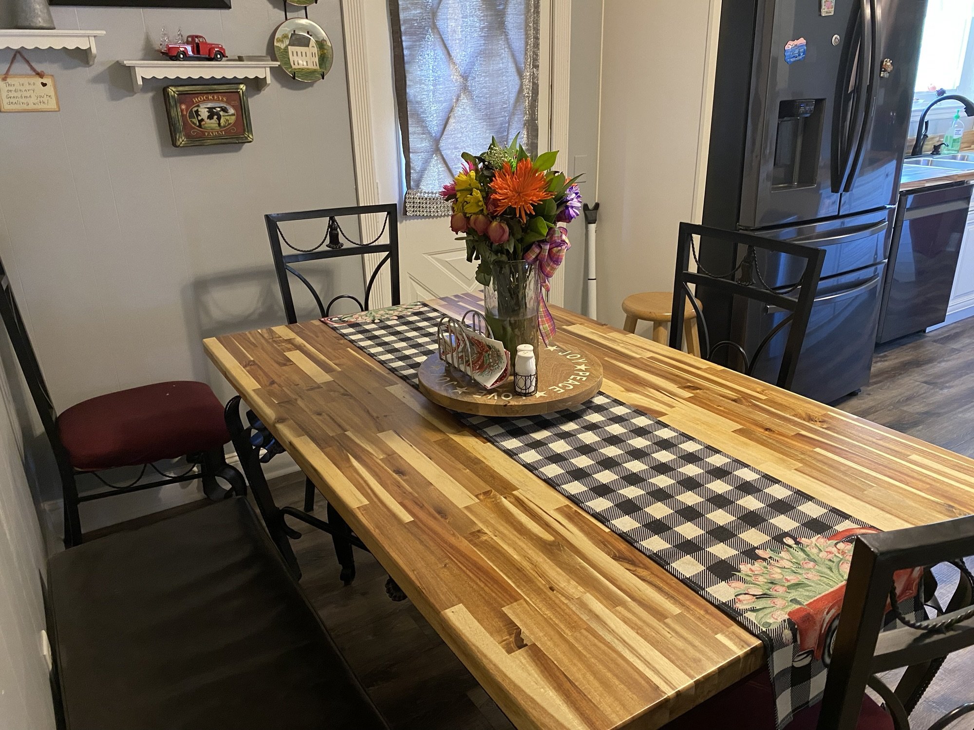 Acacia butcher block dining table in a kitchen with wood-look plank flooring
