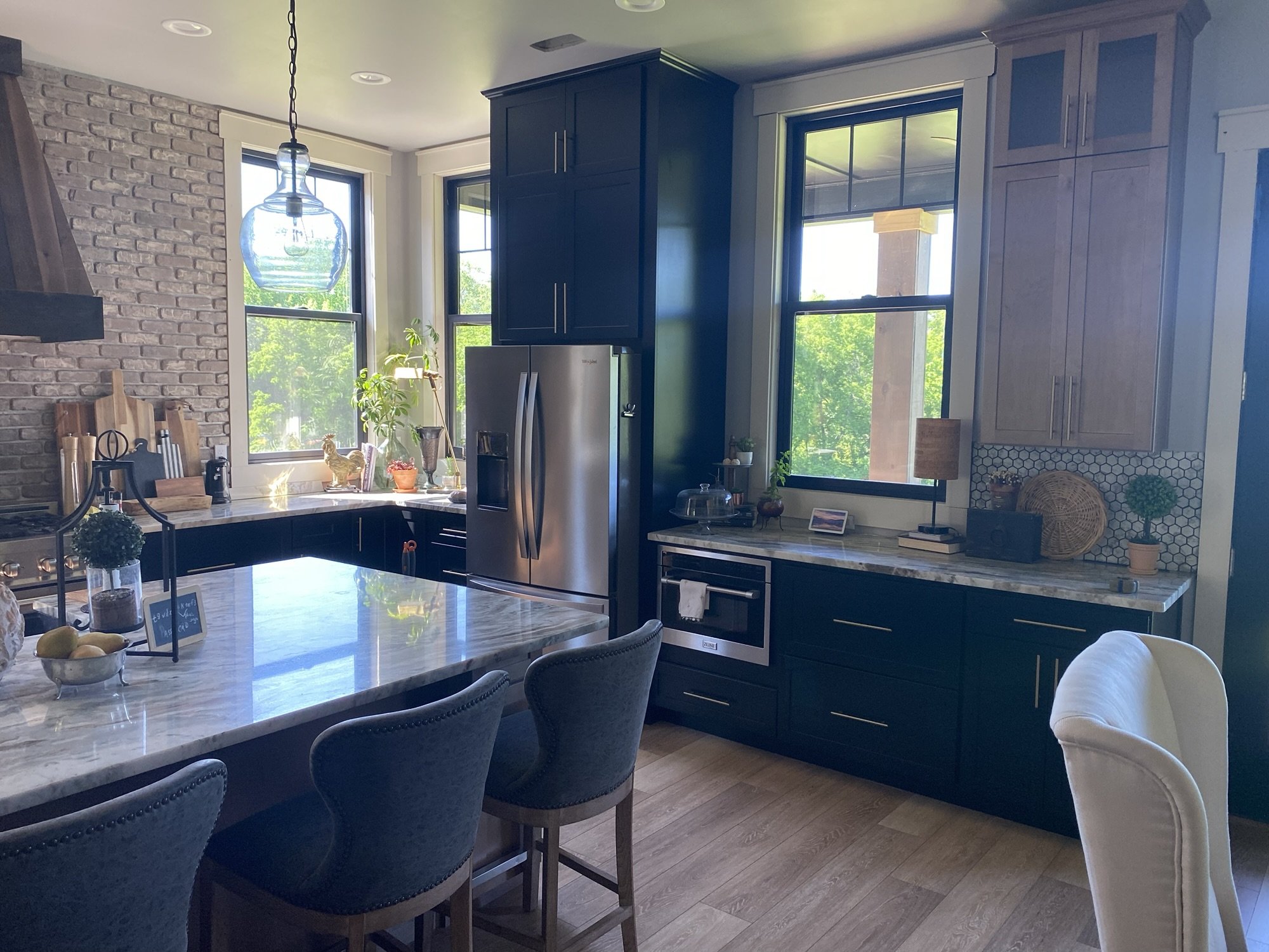 Kitchen with dark cabinetry, natural stone island, and wood-look flooring