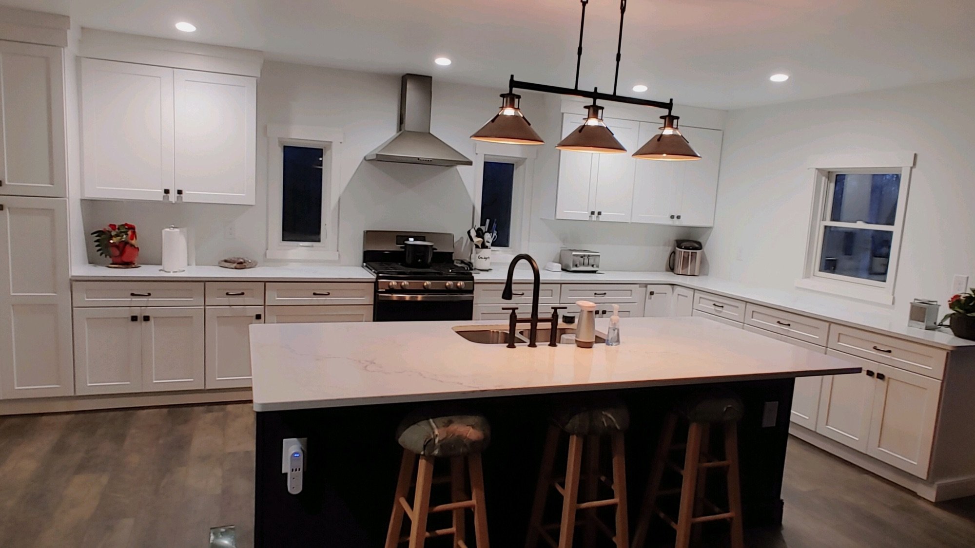 White shaker kitchen with a dark island and white quartz countertops